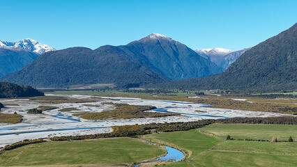 Surrounded by mountain ranges the Turiwhate River flows through farming fields on the road to Arthurs Pass