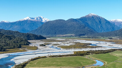 Surrounded by mountain ranges the Turiwhate River flows through farming fields on the road to Arthurs Pass