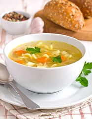A wholesome bowl of chicken noodle soup, garnished with fresh parsley, sits invitingly on a table, alongside crusty bread.