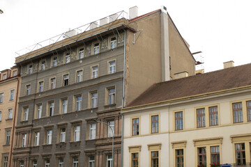 Fototapeta premium A large, impressive building that features numerous windows is situated amidst several smaller buildings in an urban landscape