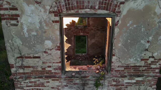 Exterior View of Crumbling Red Brick Building with Window Frames at Dusk