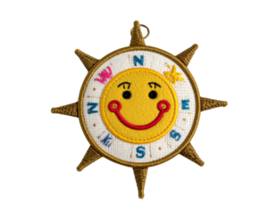 Smiling Sun Compass with Cardinal Directions and Decorative Spikes.
