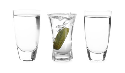 Vodka in shot glasses and one with pickle inside isolated on white