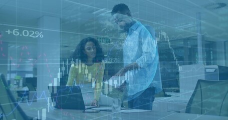 Collaborating woman in yellow top and man analyzing data at office desk with laptop and documents
