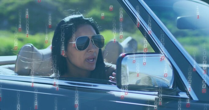 Gesturing Indian woman with sunglasses driving convertible on rural road, with binary code overlay - Powered by Adobe
