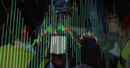 Two workers wearing safety gear examining control panel monitor in control room, with charts