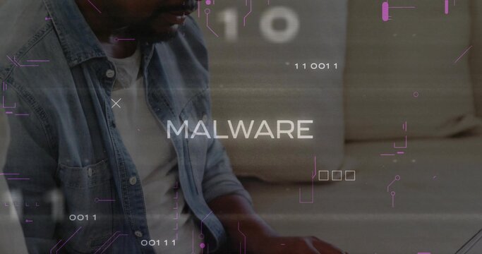 Typing man wearing denim jacket analyzing MALWARE binary code on laptop in living room, copy space