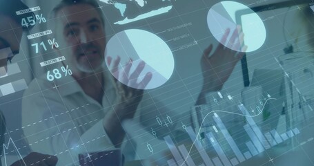 Analyzing business team in suits gesturing toward data overlay in office, with laptops and phone