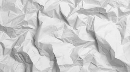 Heavily crumpled white paper shows intense creases and folds, creating a textured abstract surface perfect for backgrounds and designs needing a rough feel.