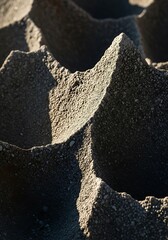 Macro image featuring textured asphalt surface with sunlight contrast