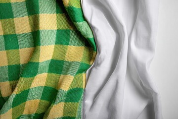 Green and yellow plaid fabric draped over white fabric