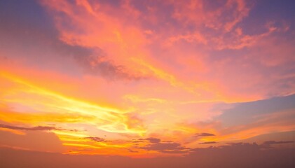 Obraz premium A breathtaking sunset paints the sky with vibrant hues of orange, pink, and purple, as fluffy clouds catch the fading light, creating a serene atmosphere.