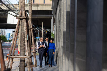 Fototapeta premium A multicultural group of business people including white and African professionals walking together in the city business district showcasing teamwork diversity and modern urban lifestyle
