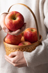 Red apple fruit (Envy apple) in basket hoding by woman hand