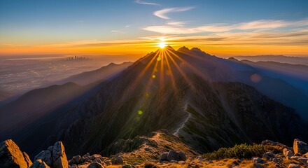 Breathtaking mountain peak sunrise with radiant sunbeams over city skyline offering inspiring scenic vista