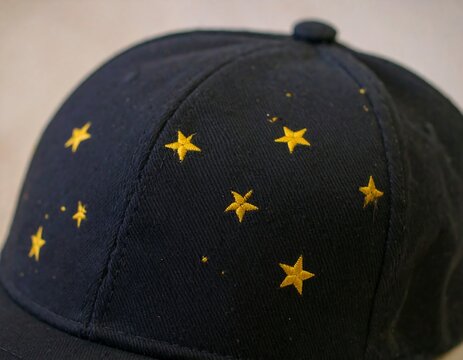 Close-up of a dark navy blue baseball cap with embroidered yellow stars