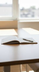 Fototapeta premium Open Notebook and Pen on Wooden Desk with Soft Natural Light