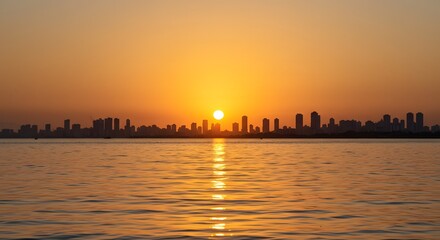 Silhouette of city skyline at sunset reflected in calm water