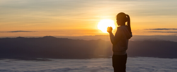  Christian catholic woman are praying to god. Christ religion and christianity worship or pray concept. Praying hands on a background of rising sun. Person believes and has faith in Jesus Christ.
