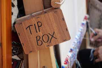 Wooden tip box at market stall for contributions