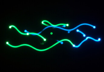 Vibrant neon light trails create dynamic abstract patterns on a dark background, perfect for tech.