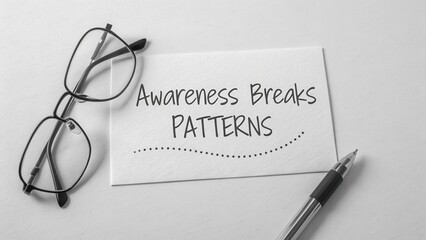 Awareness Breaks Patterns Inspirational Message on White Card with Eyeglasses and Pen in Black and White Minimalist Style