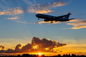 飛行機　美しい 　光　雲　空　を背景に飛ぶ　航空機