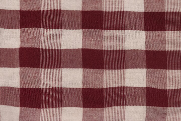 Red and White Gingham Fabric Texture. Plaid cloth fabric close-up top view. Featuring a classic checkered pattern. Picnic, farmhouse, country themes.