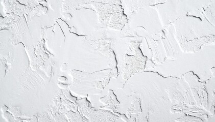 A close-up view of a white plaster wall texture, showcasing subtle imperfections, fine cracks, and a slightly uneven surface that adds character.