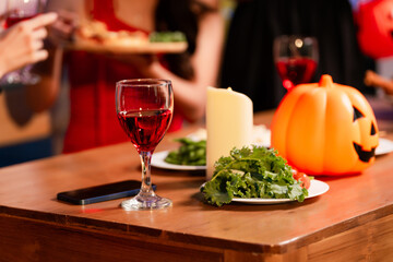 A lively Halloween party table featuring glowing pumpkin decor, festive food, and friends in costumes. celebration, creativity, and the joyful spirit of sharing spooky moments together.