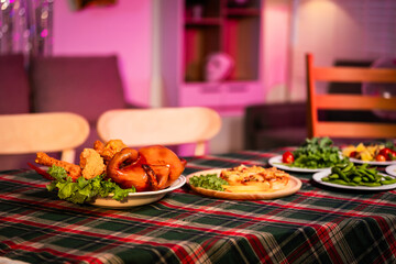 A cozy dinner table set with vibrant dishes, red wine glasses, and warm lighting, symbolizing togetherness, comfort, and the joy of sharing delicious food in a relaxed, festive atmosphere, no people.