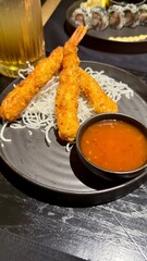 Close-up of a person using chopsticks to pick japanese food at sushi bar Sushi sashimi set Spicy tuna sushi roll topped with crispy flakes and drizzled with sauce