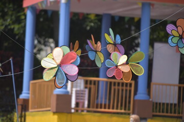 Flower Spinner. Colorful pinwheel in the wind at Garden. Rainbow colored spinner.  Windmill in garden. Simple kinetic environment decor. 