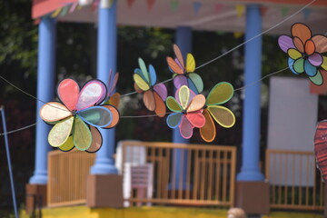 Flower Spinner. Colorful pinwheel in the wind at Garden. Rainbow colored spinner.  Windmill in garden. Simple kinetic environment decor. 