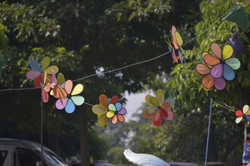 Flower Spinner. Colorful pinwheel in the wind at Garden. Rainbow colored spinner.  Windmill in garden. Simple kinetic environment decor. 