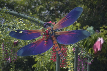 Flower Spinner. Colorful pinwheel in the wind at Garden. Rainbow colored spinner.  Windmill in garden. Simple kinetic environment decor. 
