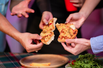 A lively group of four Asian friends cheers with red cups, celebrating a festive night gathering under colorful RGB lighting with food and a fun, energetic atmosphere.