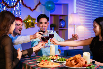 Happy friends celebrate together at home party, clinking wine glasses and sharing delicious food. The joyful moment reflects lifestyle, friendship, laughter, festive celebration in warm and colorful
