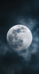Full moon shrouded in clouds at night