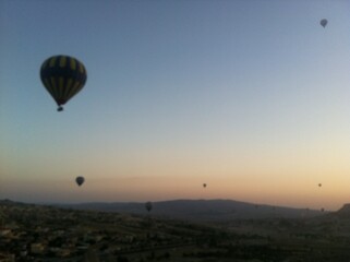 Hot Air Balloons Over Town and Rocky Landscape at Sunrise in Cappadocia, Turkey