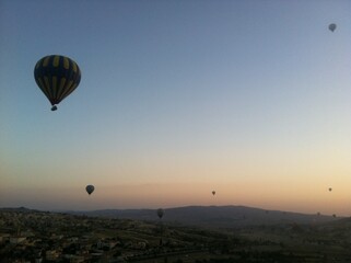 Hot Air Balloons Over Town and Rocky Landscape at Sunrise in Cappadocia, Turkey
