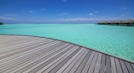 Naklejka premium Turquoise water and blue sky viewed from a wooden deck