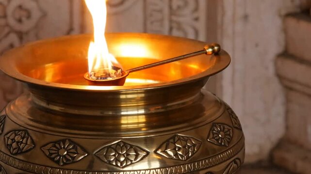 Sacred Flame Burning in an Ornate Brass Pot During a Hindu Aarti Puja Ceremony