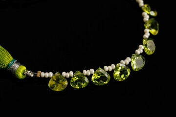Peridot Faceted Gemstones with Pearls on Black Background