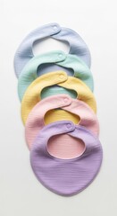 Assortment Of Pastel Colored Baby Bibs on a White Background Overhead Shot