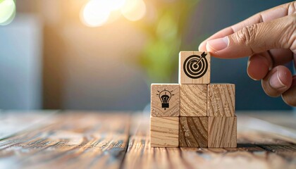 Hand placing target on wooden blocks with business goal concept.