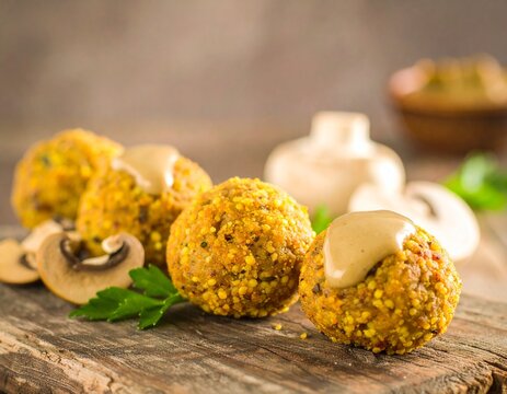 Falafel with sauce with mushrooms, and wood background Healthy food. - Powered by Adobe