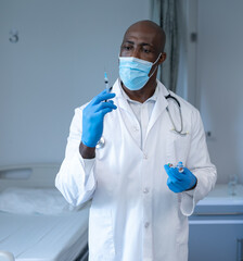 In hospital, doctor wearing mask preparing syringe with focus and precision