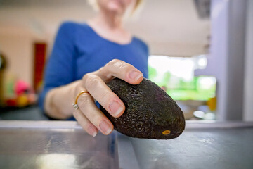 woman taking fresh avocado out of refrigerator, inside fridge perspective, everyday cooking groceries household domestic task