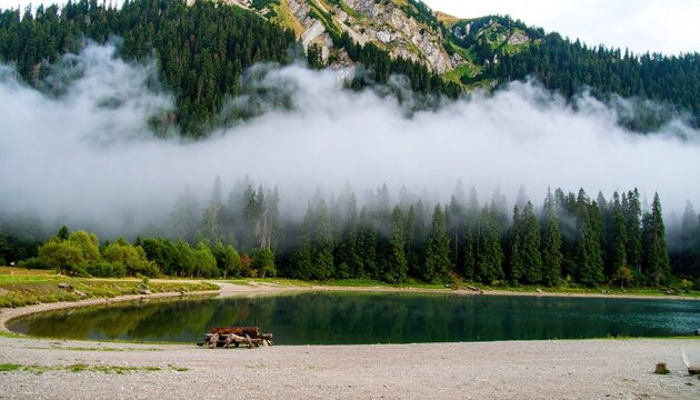 Misty Mountain Lake Landscape with Fog Rolling Over Green Trees